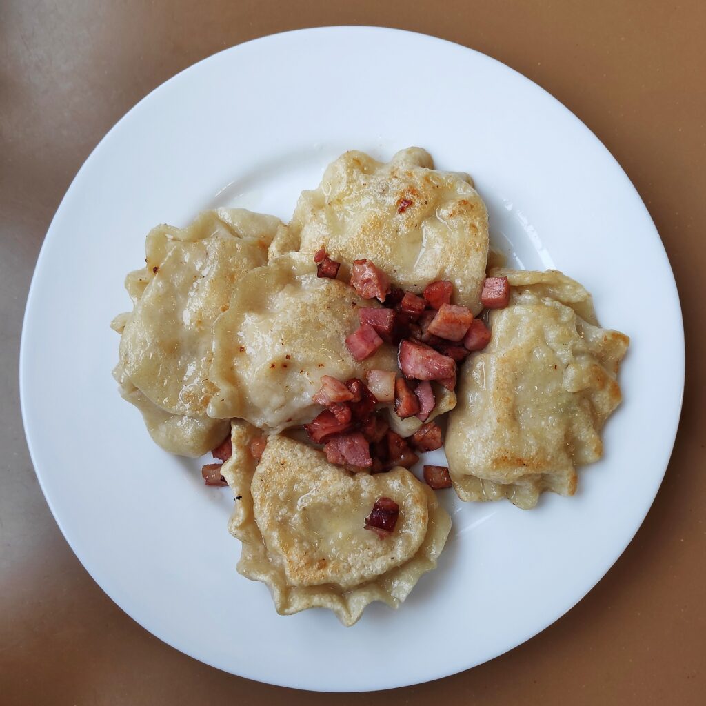 Pierogi, tradiční polské jídlo, jsou poloměkké knedlíky plněné různými náplněmi, od sýrů, masa a zeleniny, až po sladké varianty s ovocem nebo tvarohem, které dokonale ilustrují bohatost a rozmanitost polské kuchyně. Tato oblíbená specialita je symbolem polského kulturního dědictví.